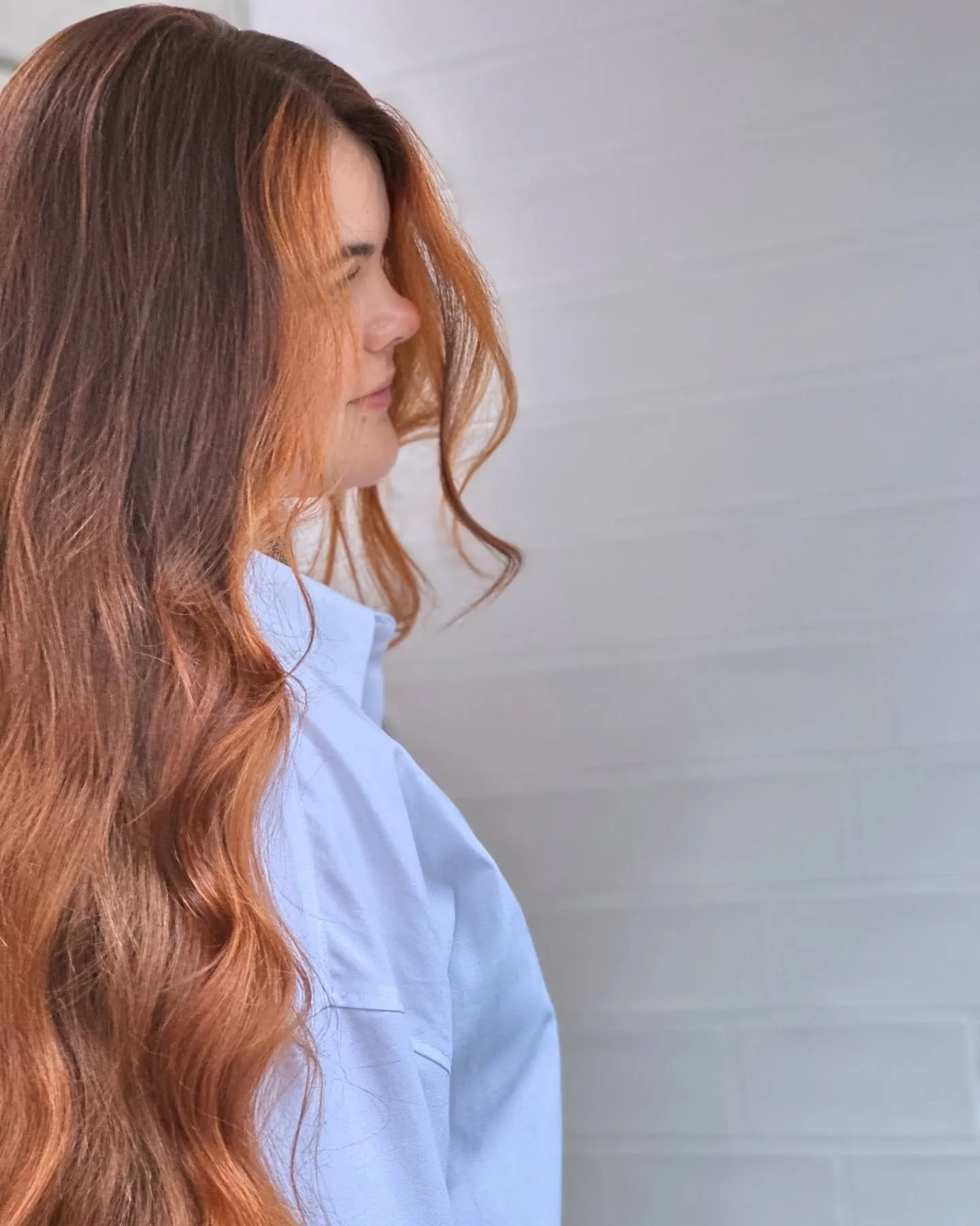 Vrouw met koperkleurig haar, van opzij gefotografeerd