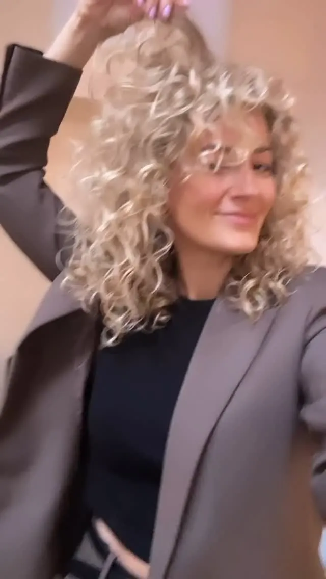 Volle blonde krullen in de salon