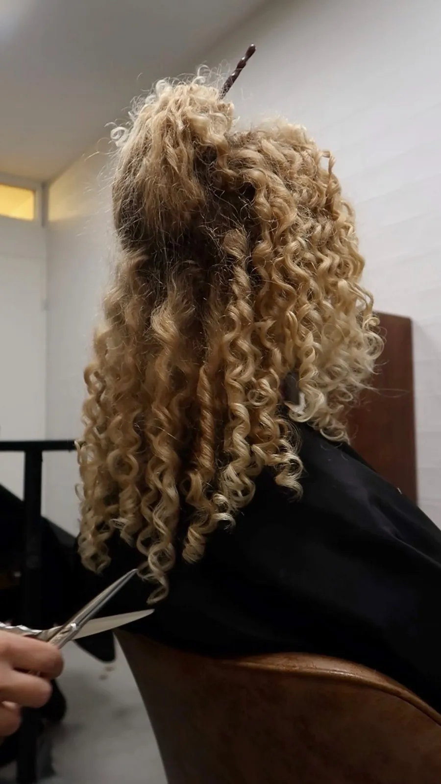 Krullen worden geknipt, van achteren gezien