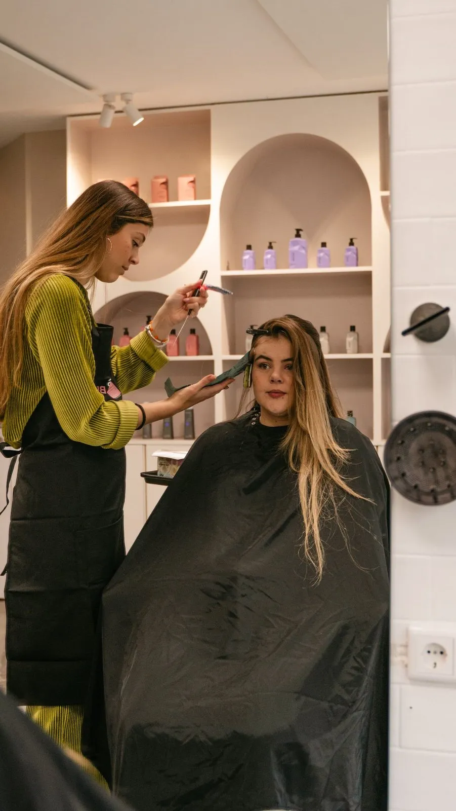Kapster aan het werk met lang haar in de salon